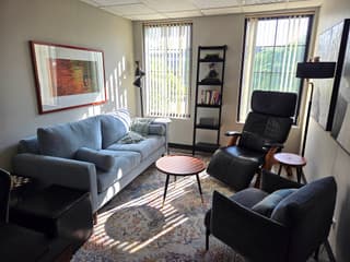 A calm, sunlit Wellbound Counseling therapy room with comfortable seating and natural light