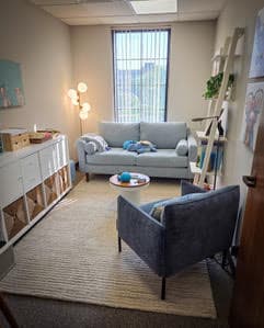 Comfortable counseling office with blue seating and soft lighting